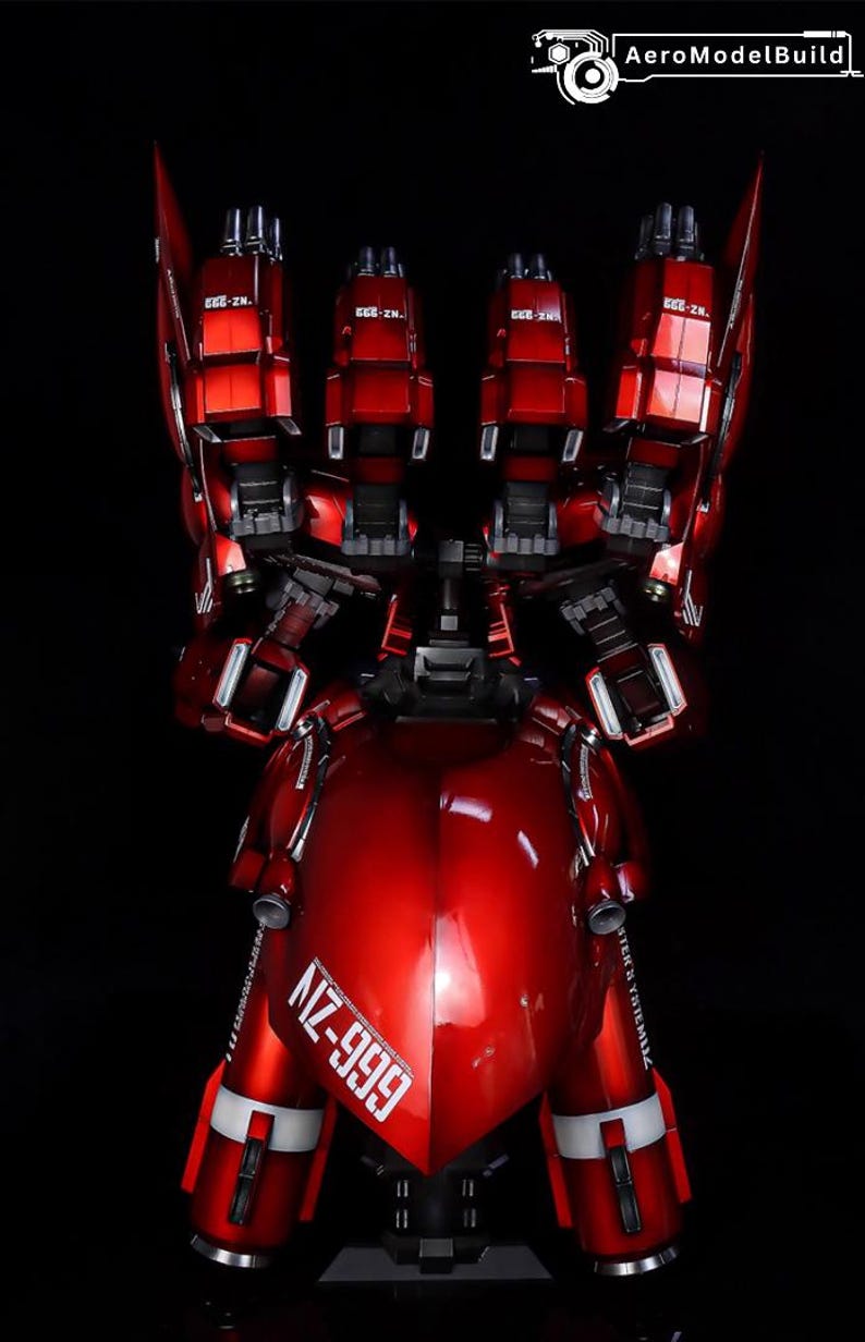 May include: A glossy red model of a robot with multiple articulated components. The model features the text "NZ-999" and "STER'S YSTEMLIZ" in white. The robot has a sleek, metallic finish and is set against a black background.