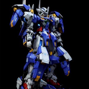 May include: A detailed model of a blue, white, and gray mecha robot with yellow accents. The robot has multiple articulated parts and is posed against a black background. The AeroModelBuild logo is in the top right corner.