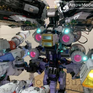 May include: A detailed model of a futuristic robot with multiple components. The model features a combination of white, blue, gray, and yellow parts, with glowing pink and blue lights. The text "ArrowModelBuild" is visible.