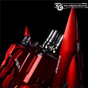May include: A close-up of a red model robot with silver metallic accents. The model has sharp angles and a glossy finish. Text on the model reads "GGG X" and "HILL UNIT SYSTEM". The background is black.