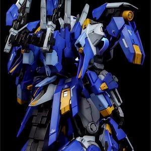 May include: A detailed model of a futuristic robot, predominantly blue with accents of yellow, gray, and black. The model features intricate mechanical details, sharp edges, and multiple weapon-like attachments. The AeroModelBuild logo is visible in the upper right corner.