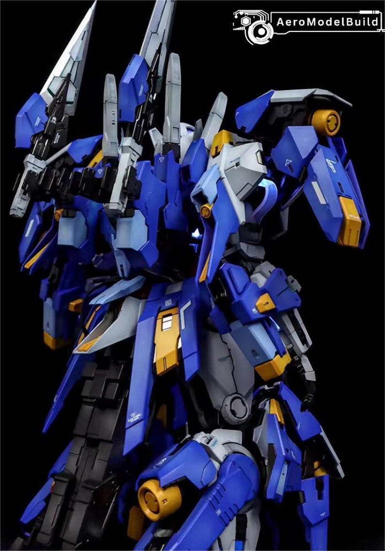 May include: A detailed model of a futuristic robot, predominantly blue with accents of yellow, gray, and black. The model features intricate mechanical details, sharp edges, and multiple weapon-like attachments. The AeroModelBuild logo is visible in the upper right corner.
