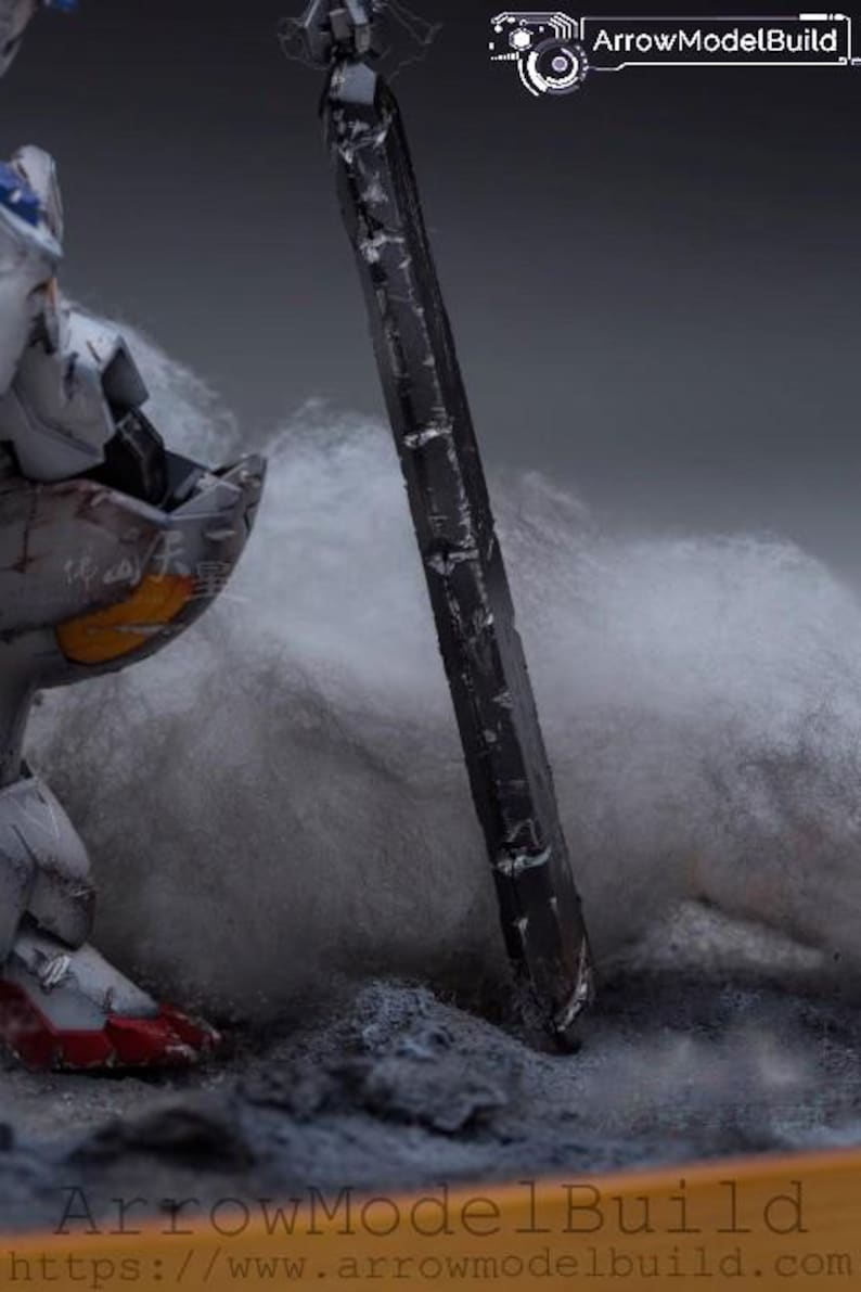 May include: A detailed model of a robot with a large, dark sword. The robot is primarily gray with red and blue accents, and the sword is black. The scene is set on a textured surface with a cloudy background.