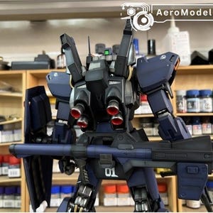 Pu&ograve; includere: Un modello di robot blu scuro con una grande arma e uno scudo. Il robot ha dettagli rossi sui suoi propulsori e il numero "01" &egrave; visibile. Il testo "AeroModelBuild" &egrave; visibile. Il modello &egrave; su uno scaffale.