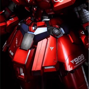 May include: A close-up of a red and black model robot with metallic details. The model has white logos and the text "NZ-999" and "999" printed on it. The text "AeroModelBuild" is also visible.