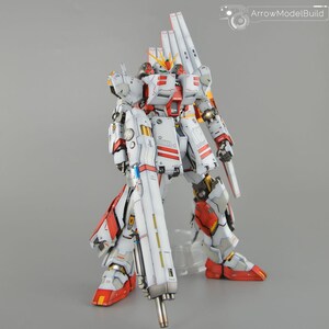 May include: A detailed model of a white, red, and grey mecha robot with a large gun. The robot has multiple panels and accents in red and yellow. The model is standing on a clear stand.