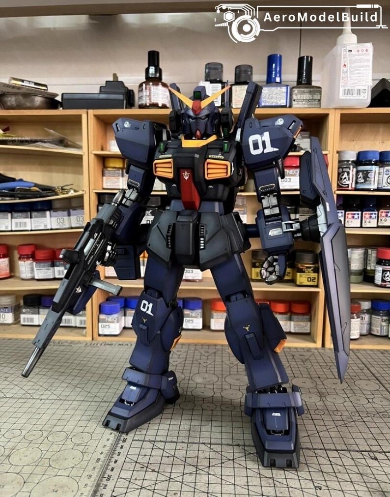 Pu&ograve; includere: Modello dettagliato di un robot mecha blu scuro e nero con accenti arancioni e gialli. Il robot &egrave; armato con un fucile e uno scudo e presenta il numero "01" sulla spalla e sulla gamba. Il modello &egrave; su una superficie a griglia.