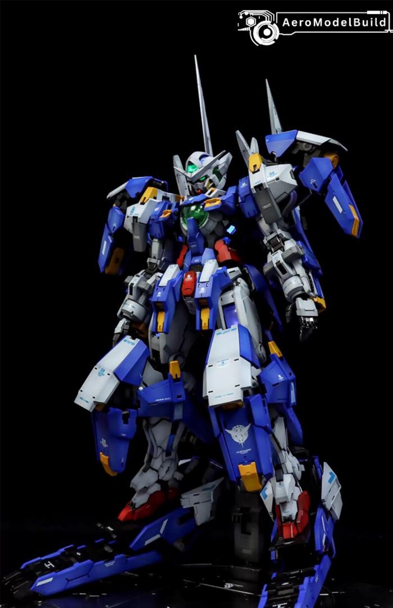 May include: A detailed model of a blue, white, and gray mecha robot with yellow and red accents. The robot has a complex design with multiple articulated parts and a long antenna. The AeroModelBuild logo is in the top right corner.