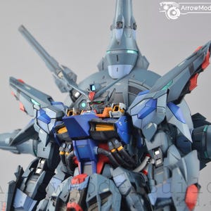 Puede incluir: Maqueta detallada de un robot futurista en azul, gris, rojo y naranja. El dise&ntilde;o complejo presenta m&uacute;ltiples partes articuladas y una estructura imponente, t&iacute;pica de un modelo mecha o Gundam.