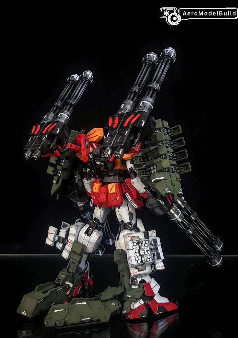 K&ouml;nnte beinhalten: Ein hochdetailliertes Mecha-Modell in den Farben Wei&szlig;, Rot und Olivgr&uuml;n. Die Figur ist mit mehreren gro&szlig;en schwarzen Gatling-Kanonen an den Schultern und am R&uuml;cken sowie mit Raketenwerfern und schwerer Panzerung ausgestattet.