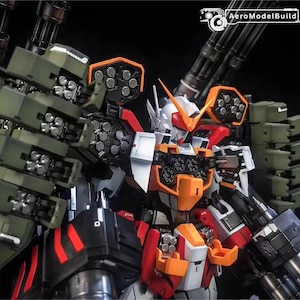 May include: A highly detailed mecha robot model in white, orange, red, black, and olive green. The robot is heavily armed with multiple missile launchers and cannons, showcasing intricate mechanical details. The AeroModelBuild logo is visible in the top right corner.