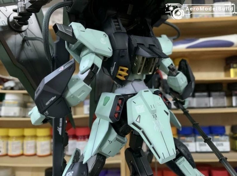 Puede incluir: Maqueta detallada de un robot mec&aacute;nico, con una combinaci&oacute;n de colores negro, verde menta y detalles en rojo. El robot tiene extremidades articuladas y detalles intrincados en los paneles. El logo AeroModelBuild es visible.