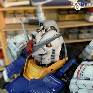 K&ouml;nnte beinhalten: Nahaufnahme eines detaillierten, bemalten Robotermodells. Der Roboter hat einen wei&szlig;en Kopf mit roten und grauen Akzenten, eine gelbe Brust und blaue R&uuml;stung. Das Modell ist sehr detailliert, mit sichtbaren mechanischen Komponenten.