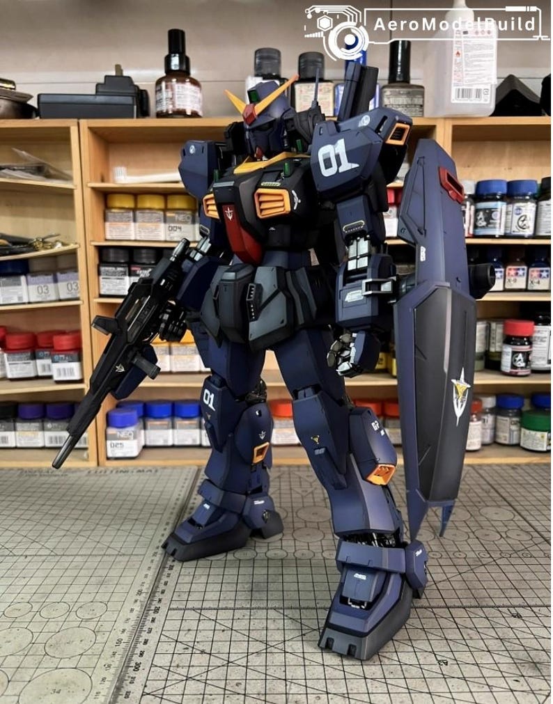 Pu&ograve; includere: Modello dettagliato di un robot mecha blu scuro e nero con accenti arancioni e gialli. Il robot ha un grande scudo e un fucile. Il numero "01" &egrave; visibile sulla spalla e sulla gamba. Il modello &egrave; ambientato su uno sfondo di barattoli di vernice e scaffali.