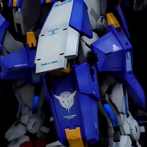 May include: Close-up of a detailed model kit of a robot, featuring a combination of blue, white, and yellow components. The model has intricate designs and the text "CELESTIALWING" is visible. The kit is likely for hobbyists and collectors.