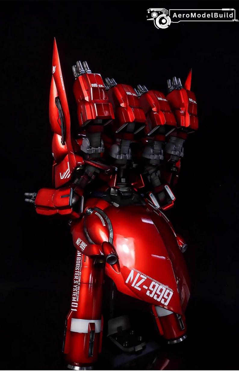 May include: A detailed, red model of a futuristic robot with multiple thrusters and the text "NZ-999". The model has a glossy finish and intricate mechanical details, set against a black background.