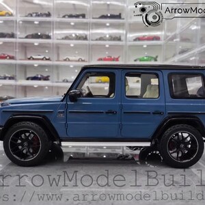 May include: A blue model SUV with black wheels and a spare tire on the back. The vehicle has a black roof and trim. The text "ArrowModelBuild" and a website address are visible at the bottom of the image.