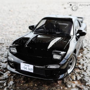 Könnte beinhalten: Ein glänzendes schwarzes Modellauto mit Spoiler und silbernen Felgen. Das Auto hat ein Nummernschild mit der Nummer "54-369". Das Bild enthält den Text "ArrowModelBuild" und eine Website-Adresse.