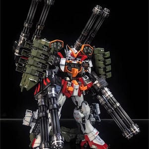 May include: A highly detailed model robot, showcasing a complex design with numerous cannons and weaponry. The robot is predominantly white, red, and orange, with black and silver detailing. The image is set against a dark backdrop, emphasising the intricate details of the model.