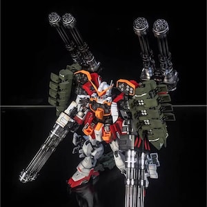 May include: A detailed model of a mecha robot, with a colour scheme of white, red, orange, and green. The robot is heavily armed with multiple large-calibre cannons and missile launchers. The AeroModelBuild logo is visible in the top right corner.