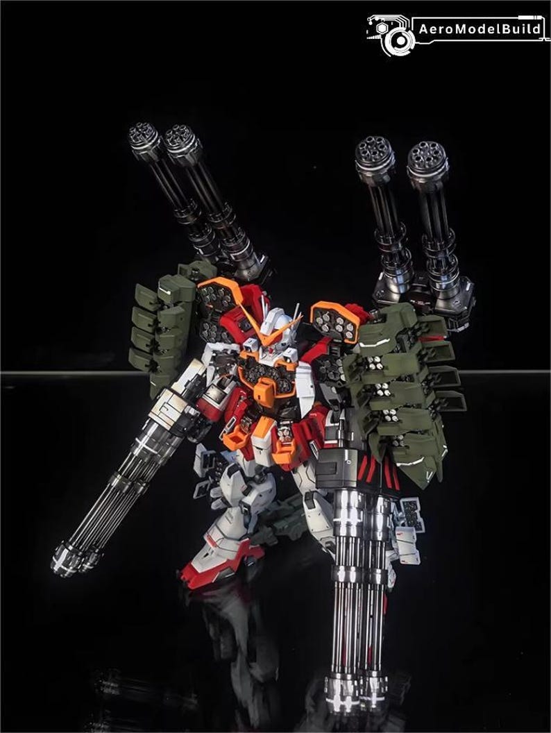 May include: A detailed model of a mecha robot, with a colour scheme of white, red, orange, and green. The robot is heavily armed with multiple large-calibre cannons and missile launchers. The AeroModelBuild logo is visible in the top right corner.