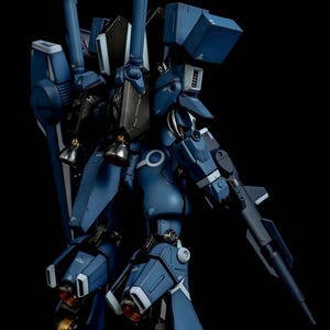 May include: A detailed model of a blue and gray mecha robot, featuring intricate mechanical details, including a gun, thrusters, and multiple articulated joints. The model is set against a black background, highlighting its design. The AeroModelBuild logo is in the top right corner.