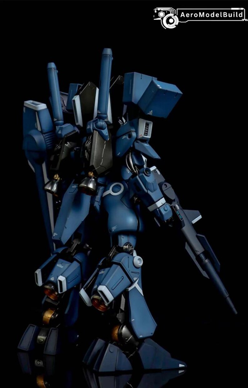May include: A detailed model of a blue and gray mecha robot, featuring intricate mechanical details, including a gun, thrusters, and multiple articulated joints. The model is set against a black background, highlighting its design. The AeroModelBuild logo is in the top right corner.