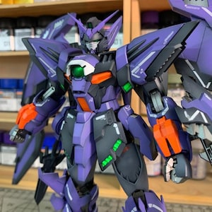 May include: A detailed model of a purple and black robot with orange and green accents. The robot has large wings and is posed with its arms out. The text "ArrowModelBuild" is visible in the image.