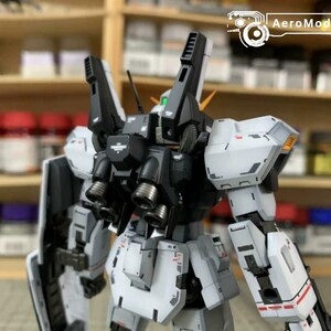 Pode incluir: Kit de modelo detalhado de um rob&ocirc; mecha, principalmente branco e preto, com detalhes mec&acirc;nicos intrincados. O rob&ocirc; tem grandes componentes montados nos ombros e m&uacute;ltiplos propulsores. O logotipo AeroModelBuild &eacute; vis&iacute;vel.
