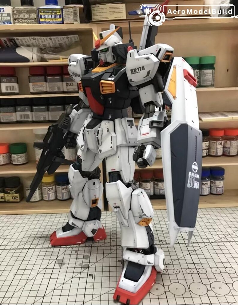 Op de afbeelding: Gedetailleerd model van een witte, zwarte en rode robot met een schild en een geweer. De robot heeft ingewikkelde mechanische details en staat op een rasteroppervlak. Een verzamelobject.