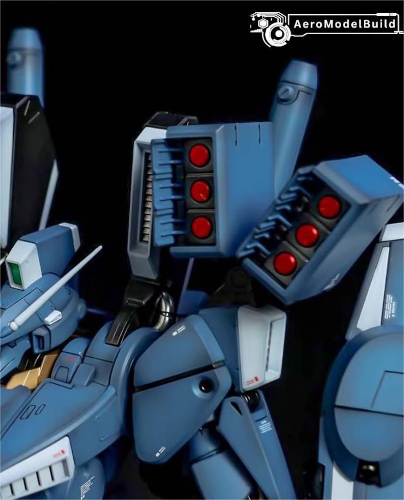 May include: Close-up of a detailed blue model with red missile details. The model features multiple sections, including a missile launcher with six red missiles. The model has the text "AeroModelBuild" in the upper right corner.