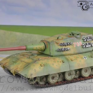 May include: A detailed model tank in camouflage colours of green, brown, and yellow. The tank has a long barrel, visible tracks, and the number "708" on the turret. The model is set against a backdrop of a green field and a light blue sky.
