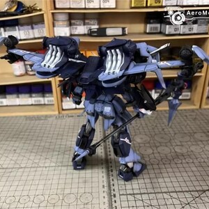 May include: A detailed model of a futuristic robot, primarily in shades of blue and black, with intricate mechanical details. The robot has large, wing-like structures and is holding a weapon. The model is set against a backdrop of shelves filled with model-building supplies.