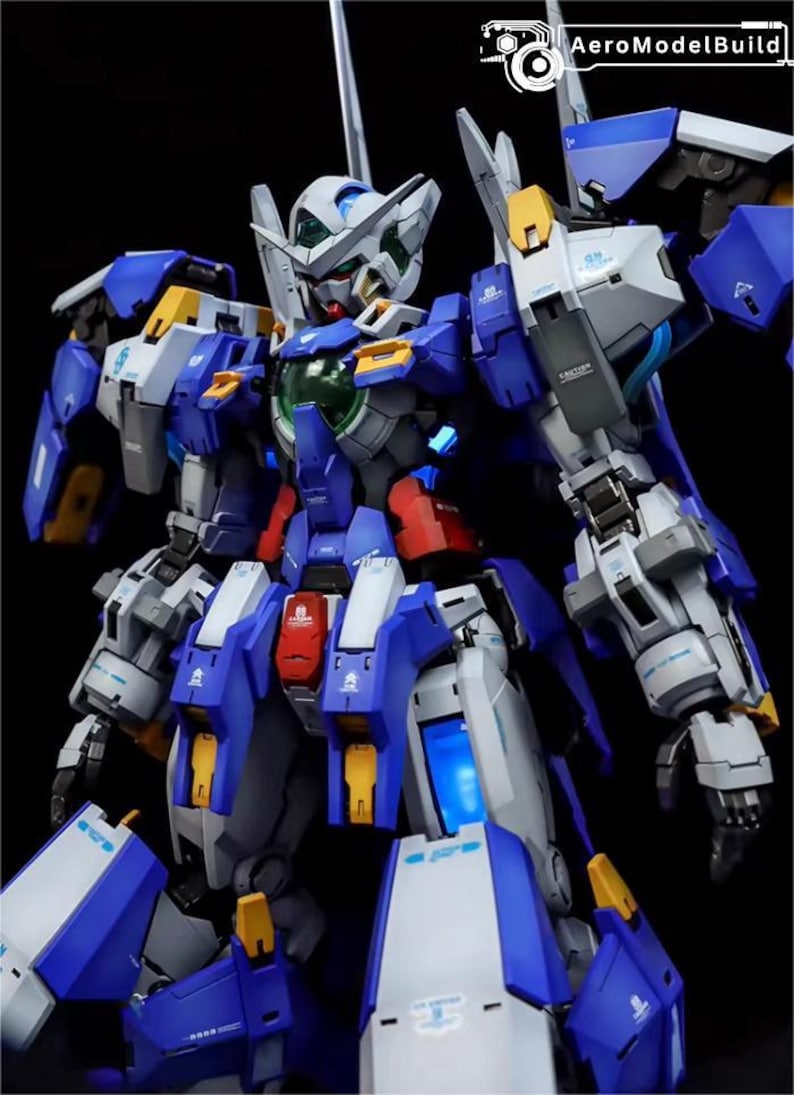 May include: A detailed model kit of a futuristic robot, primarily in shades of blue, white, gray, and yellow. The robot features intricate mechanical details, including articulated limbs, panels, and a head with a distinctive design. The model is set against a black background.