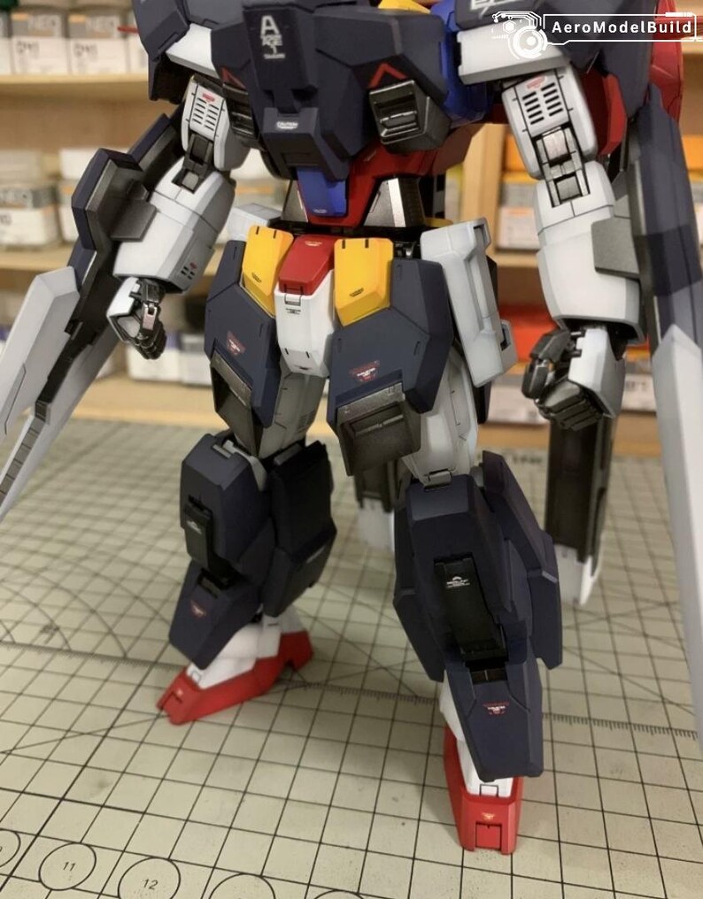 Puede incluir: Kit de modelo de robot mecha parcialmente ensamblado. El robot presenta una combinaci&oacute;n de colores azul marino, blanco, rojo, amarillo y plateado. Tiene extremidades articuladas y se presenta con una gran cuchilla. El modelo es muy detallado.