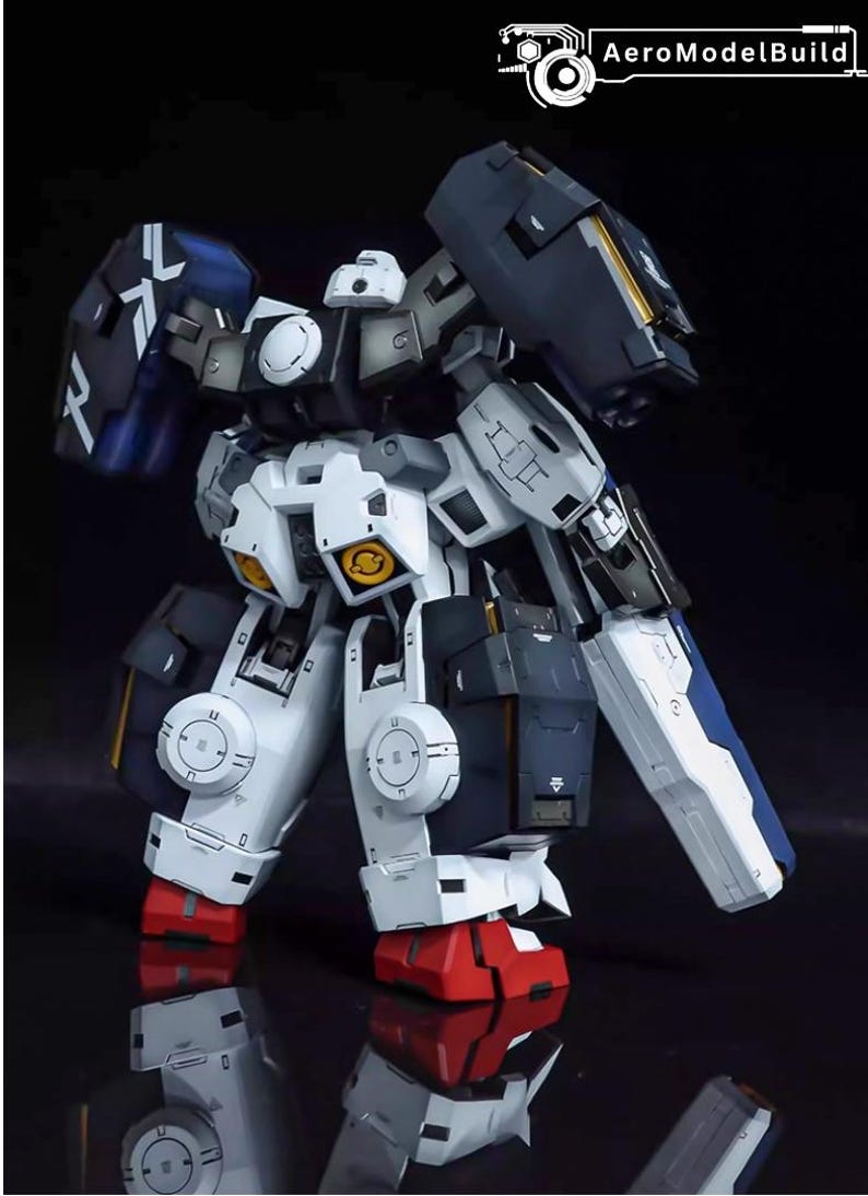 May include: A detailed model of a robot with a white, navy blue, and black color scheme. The model has intricate mechanical details, including articulated limbs, shields, and yellow accents. The robot's feet are red, and the model is set against a dark background.