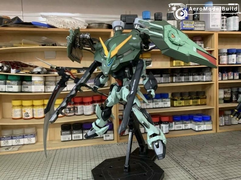 Puede incluir: Un modelo detallado de un robot mecha verde y blanco con grandes cuchillas y un escudo. El robot est&aacute; posado sobre un soporte negro, con un dise&ntilde;o detallado y m&uacute;ltiples partes articuladas. El fondo muestra estantes con suministros de pintura.