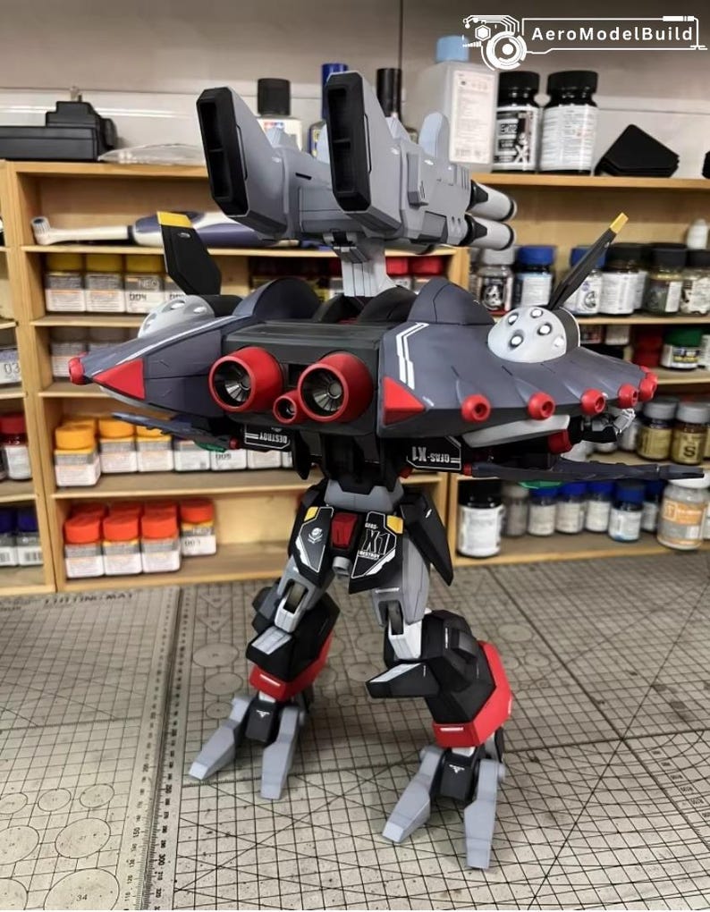 May include: A detailed model of a futuristic aircraft or robot, primarily in shades of gray, black, and red. The model features multiple jet engines, wings, and a complex mechanical design. The text "AeroModelBuild" is visible.
