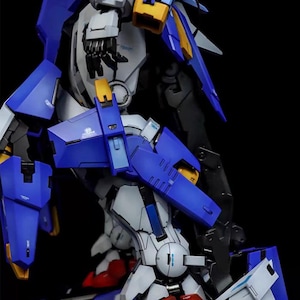 May include: A detailed model kit of a robot, featuring a combination of blue, white, yellow, and red components. The model has intricate mechanical details and is set against a black background. The text "AeroModelBuild" is visible in the upper right corner.