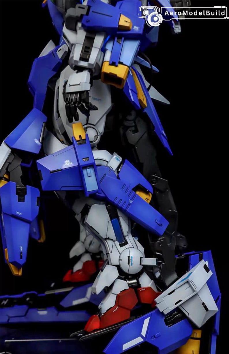 May include: A detailed model kit of a robot, featuring a combination of blue, white, yellow, and red components. The model has intricate mechanical details and is set against a black background. The text "AeroModelBuild" is visible in the upper right corner.