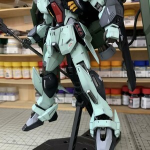 Puede incluir: Modelo detallado de un robot Gundam, con una combinaci&oacute;n de colores verde azulado claro, negro y detalles rojos. El robot est&aacute; posado sobre un soporte negro, mostrando su intrincado dise&ntilde;o y armamento. Es un art&iacute;culo de colecci&oacute;n.