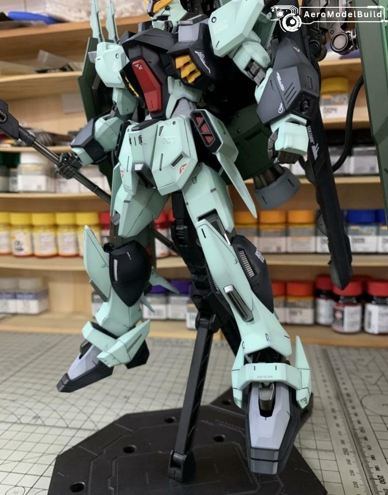Puede incluir: Modelo detallado de un robot Gundam, con una combinaci&oacute;n de colores verde azulado claro, negro y detalles rojos. El robot est&aacute; posado sobre un soporte negro, mostrando su intrincado dise&ntilde;o y armamento. Es un art&iacute;culo de colecci&oacute;n.