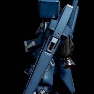 May include: AeroModelBuild logo on a dark background. The image features a detailed, blue model of a futuristic robot or mech. The model has angular panels, metallic accents, and intricate mechanical details.