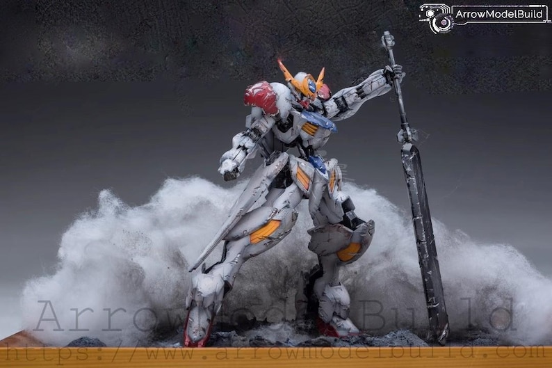 May include: A detailed model of a white, gray, and orange mech robot with a large sword, posed against a backdrop of stylized smoke. The robot has red accents and is standing on a wooden base. The image includes the text "ArrowModelBuild".