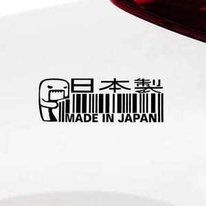 Può includere: Adesivo in bianco e nero con testo giapponese e un personaggio dei cartoni animati. Il testo include "Made in Japan" e un design a codice a barre. L'adesivo è probabilmente per un'auto o un altro veicolo.