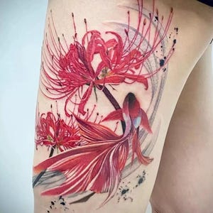 Pode incluir: Um design de tatuagem vibrante com lírios-aranha vermelhos e um peixe betta vermelho e branco. A obra de arte inclui uma pincelada circular cinza e respingos de tinta preta.