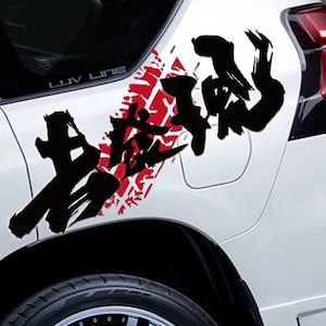 May include: A white car with a black tire and a red tire track design. The car has a black Japanese calligraphy design on the side. The text "LUV LINE" is visible on the car.