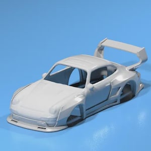 May include: A white sports car model with a large rear wing, set against a blue background. The car has a sleek design with visible wheel wells and a low profile, suggesting a racing or high-performance vehicle.