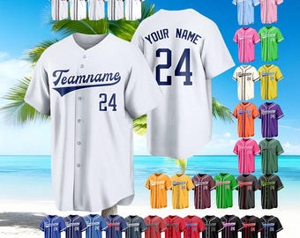 Pode incluir: Camisola de beisebol branca com "Teamname" e o número 24 em azul marinho. Camisolas adicionais em várias cores são exibidas, incluindo azul, rosa, verde e amarelo. A parte de trás da camisola mostra "YOUR NAME" e o número 24.