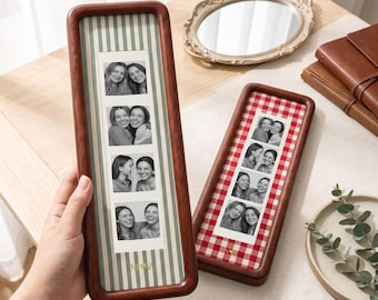 May include: Two tall, rectangular wooden photo frames with rounded corners. One frame features a green and white striped background with the letters M and Z separated by a heart. The other has a red and white gingham background with the letters N and Z separated by a heart. Each frame holds a vertical strip of four black and white photos showing two people smiling.